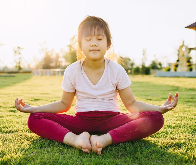 Child sitting comfortably on a treated lawn